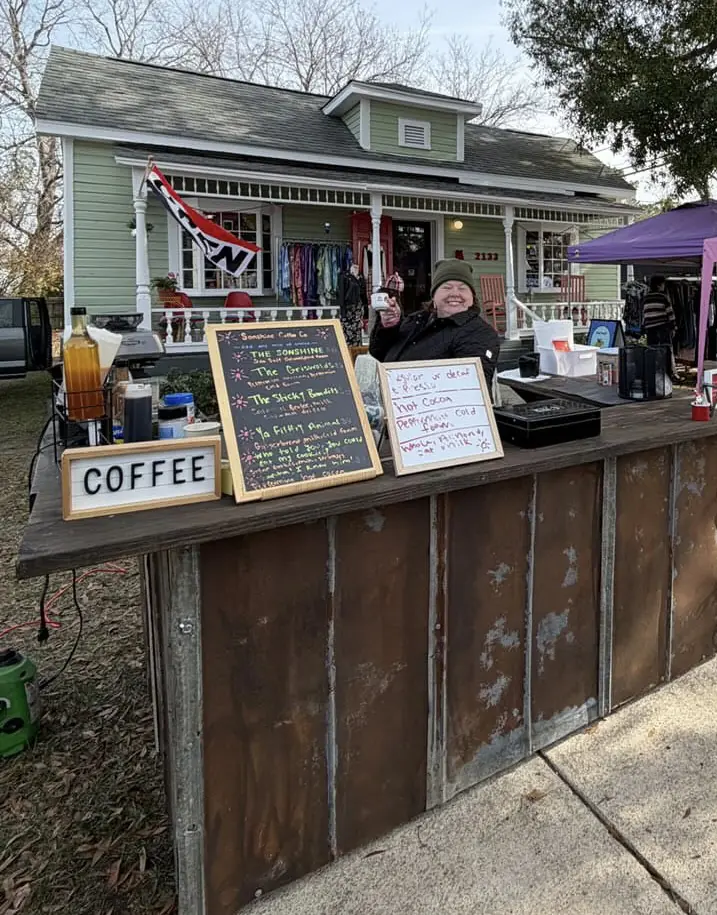 The cart parked outside a shop, COFFEE sign hung on the front and menu boards either side.