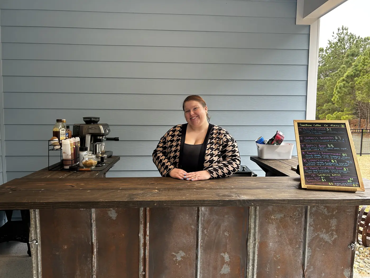 The coffee cart set up outside, chalkboard menu propped on the bar.