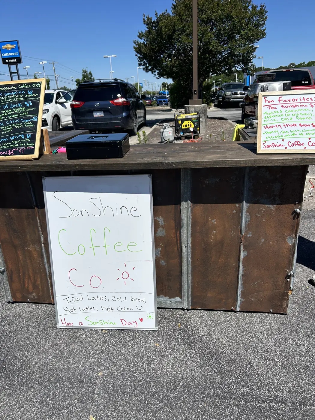A hand-lettered Sonshine Coffee Co sign at a roadside market stall.